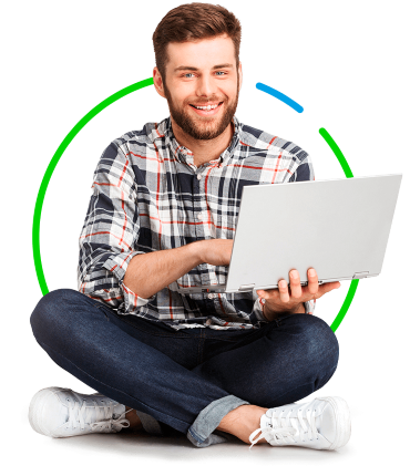 Homem sorridente sentado de pernas cruzadas no chão, segurando um laptop, vestindo uma camisa xadrez e calça jeans, com um gráfico circular verde ao fundo.